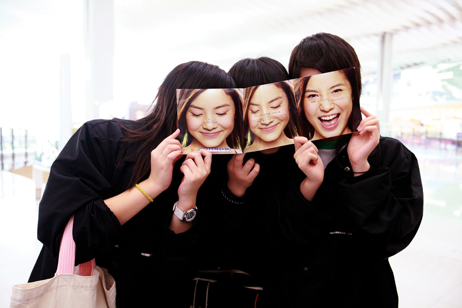 用广告单挡住面孔的黑衣服女子。香港